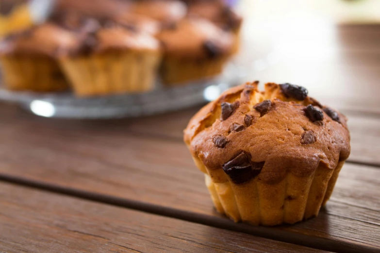 a muffin sitting on top of a wooden table, by Mathias Kollros, pexels, square, chocolate, loaves, slim