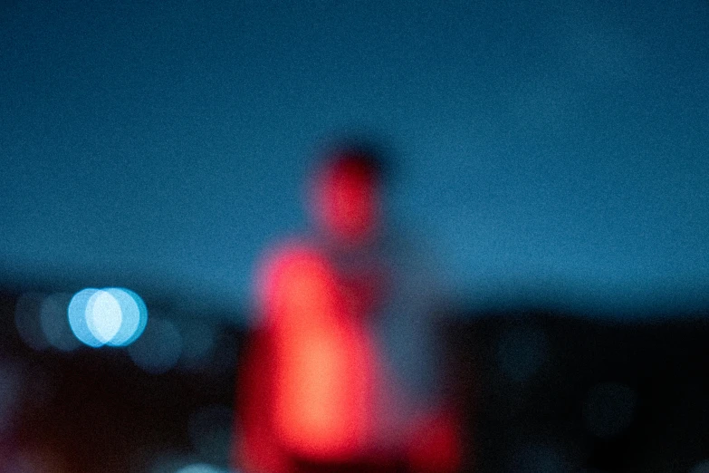 a blurry image of a man in a red shirt, by Adam Marczyński, pexels contest winner, digital art, blue and red lights, tiny person watching, closeup photograph, blue and red two - tone