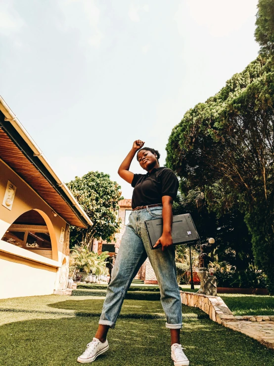 a woman standing on top of a lush green field, an album cover, by Ingrida Kadaka, pexels contest winner, happening, in front of the house, holding a bottle of beer, wearing a shirt and a jean, holding notebook