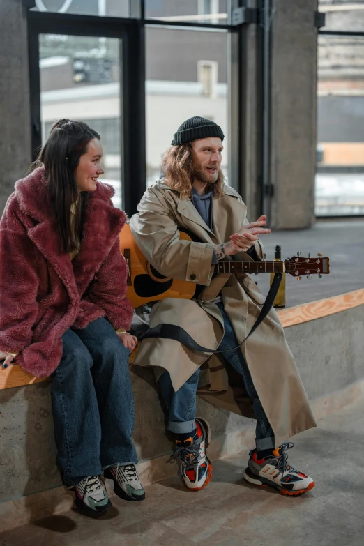 a couple of people that are sitting on a bench, a portrait, by Jaakko Mattila, trending on pexels, performing a music video, homeless, wearing a long coat, hippie