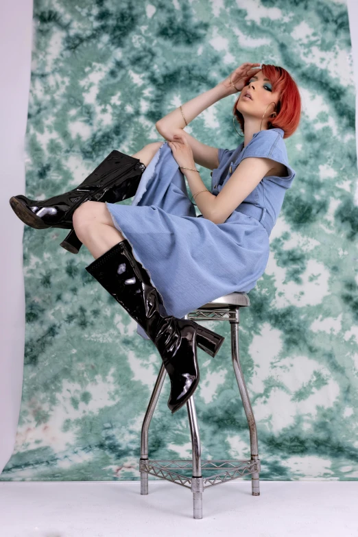 a woman in a blue dress sitting on a stool, an album cover, inspired by Jean Hey, featured on reddit, wearing tall combat boots, model エリサヘス s from acquamodels, leeloo outfit, catalog photo