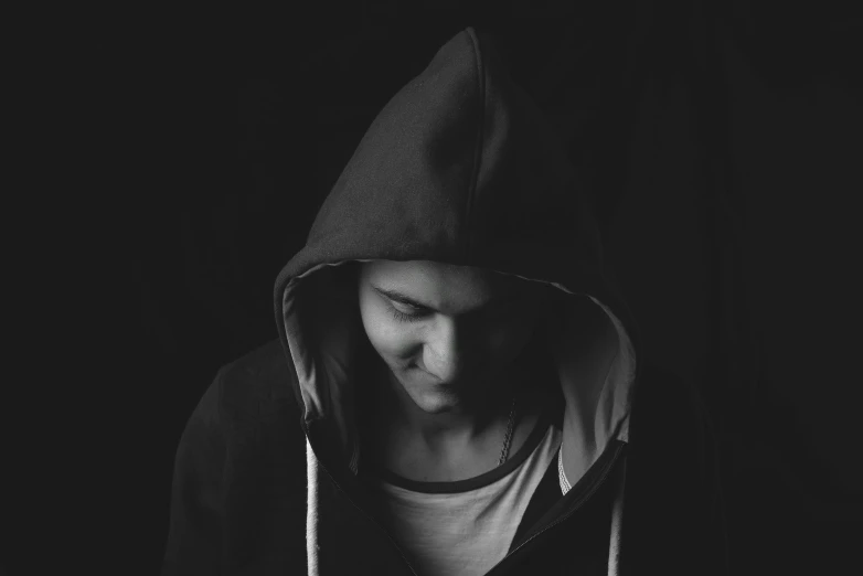a black and white photo of a man in a hoodie, pexels, antipodeans, young female, black teenage boy, album cover, black hoodie techie