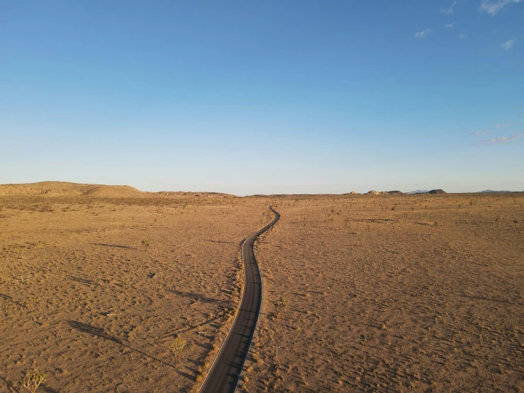 a dirt road in the middle of a desert, by Julian Allen, land art, trailing off into the horizon, a high angle shot, ignant, new mexico