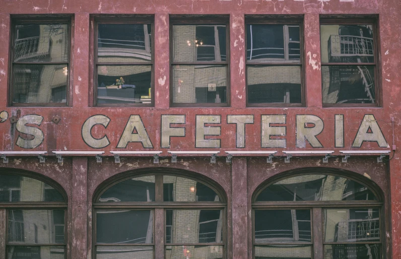 a sign that is on the side of a building, inspired by Cafer Bater, pexels contest winner, cafe interior, 1 9 0 0's photo, brown, joel fletcher