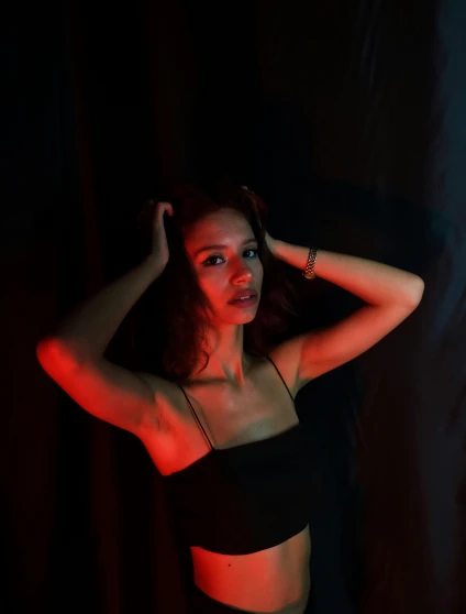 a woman in a black top posing for a picture, an album cover, inspired by Elsa Bleda, pexels contest winner, red glowing skin, contour light effect!! 8 k, dark dance photography aesthetic, medium portrait top light