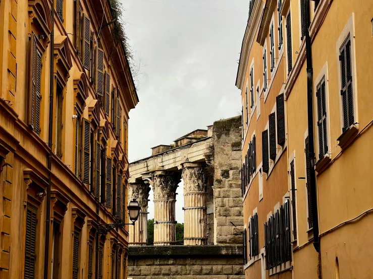 a couple of buildings that are next to each other, inspired by Hubert Robert, pexels contest winner, neoclassicism, lots of roman arches, view from the streets, brown, grey