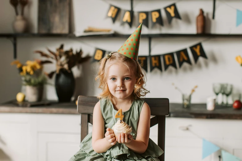 a little girl sitting in a chair with a birthday hat on, pexels, cone shaped, black, thumbnail, cupcake