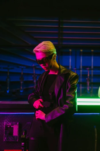 a man standing in front of a neon sign, an album cover, trending on pexels, holography, cai xukun, in a nightclub, dark shades, cinematic outfit photo
