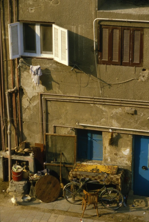 a building with a bicycle parked in front of it, an album cover, flickr, renaissance, belongings strewn about, mediterranean fisher village, ( ( photograph ) ), detail