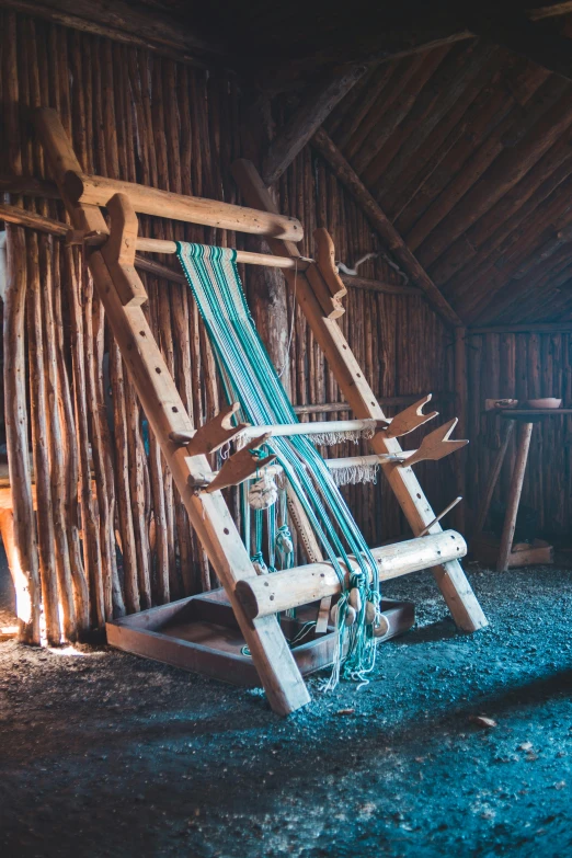 a close up of a weaving machine in a room, by Jessie Algie, trending on unsplash, arts and crafts movement, medieval village on the plains, iceland, brown and cyan color scheme, tied with chair