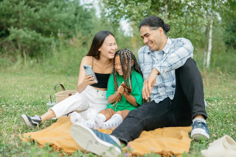 a man and woman sitting on a blanket in the grass, families playing, gen z, an olive skinned, avatar image