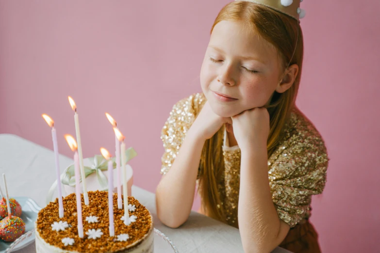 a little girl sitting in front of a birthday cake, an album cover, pexels, a redheaded young woman, background image, candle wax, tiara