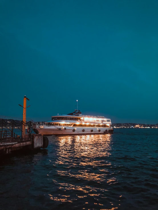 a boat that is sitting in the water, at night time, surrounding the city, profile image, multiple stories