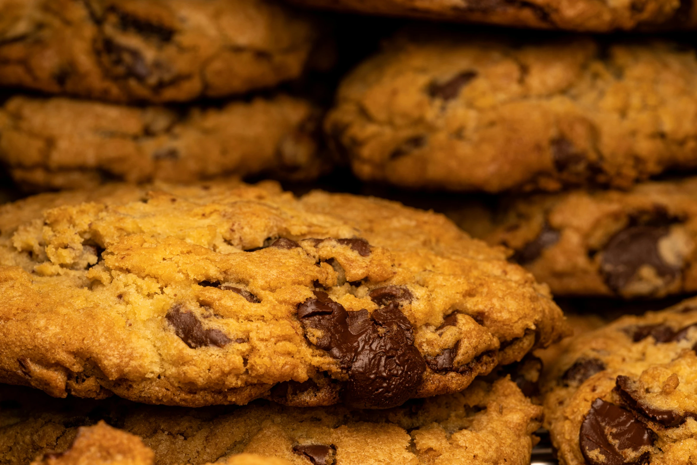 a pile of chocolate chip cookies sitting on top of each other, by Niko Henrichon, pexels, background image, high-resolution photo, thumbnail, manhattan