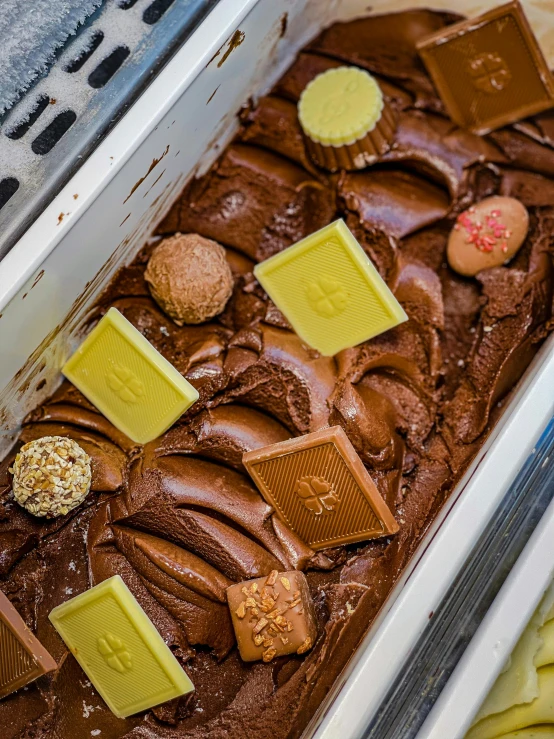 a pan of chocolate cake sitting on top of a counter, inspired by Joris van der Haagen, unsplash, process art, ice cream, yellow, high quality product image”