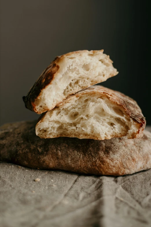 two pieces of bread stacked on top of each other, a portrait, by Tom Bonson, unsplash, soft cracks, linen, arched back, sparkling