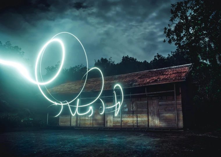 a person standing in front of a building with a light painting on it, inspired by Cerith Wyn Evans, pexels contest winner, orb, in front of a garage, electric swirls, (fantasy)