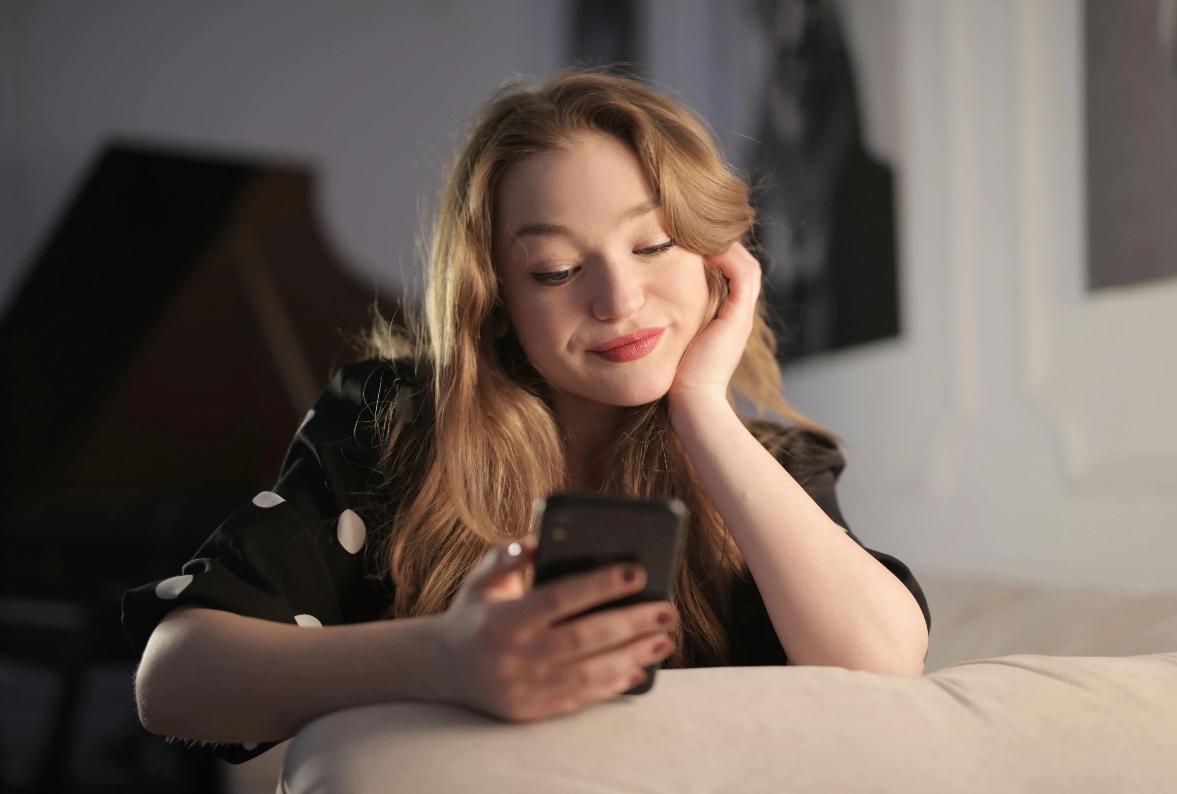 a woman sitting on a couch looking at a cell phone, a portrait, trending on pexels, eleanor tomlinson, 15081959 21121991 01012000 4k, goodnight, sydney sweeney