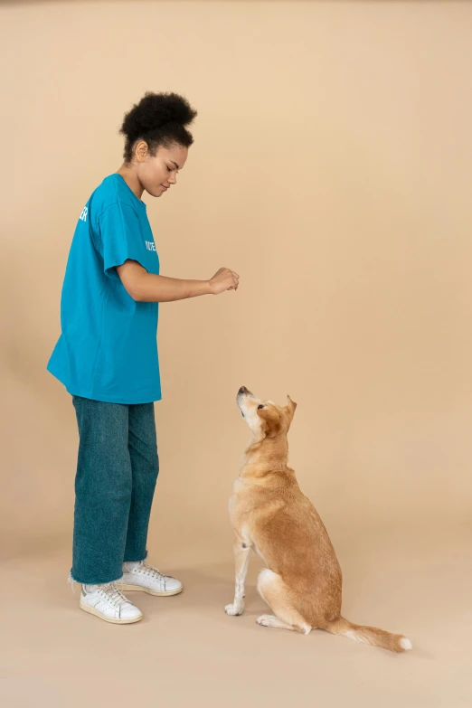 a boy in a blue shirt standing next to a brown dog, trending on unsplash, cyan photographic backdrop, fist training, teenage girl, lab coat and tee shirt