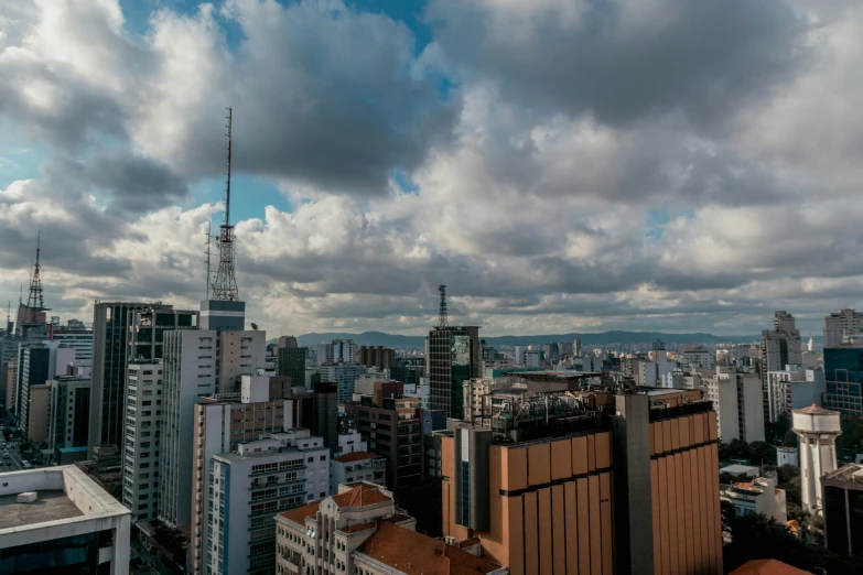 a view of a city from the top of a building, by Felipe Seade, fan favorite, 4k panoramic, clouds around, buildings