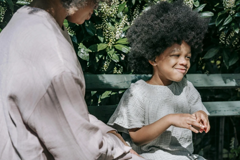 a woman sitting next to a little girl on a bench, pexels contest winner, afro comb, gardening, sleek hands, with textured hair and skin