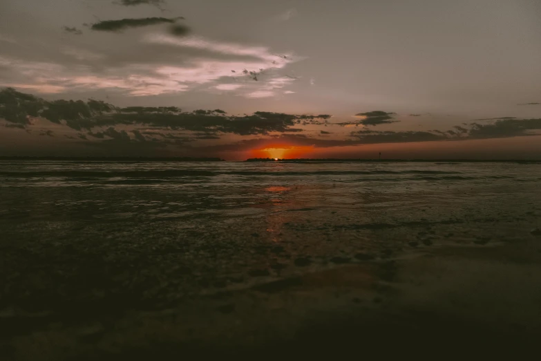 the sun is setting over the water at the beach, by Emma Andijewska, unsplash contest winner, australian tonalism, brown, hd wallpaper, low - angle shot, slight overcast