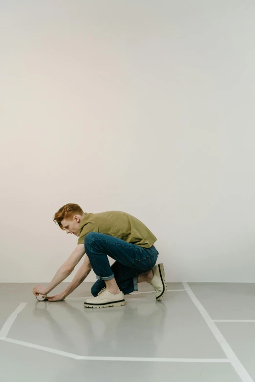 a man kneeling on a skateboard in a white room, by Lee Gatch, visual art, sophia lillis, wearing cargo pants, green floor, profile pic