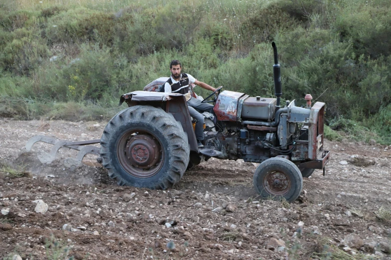 a man driving a tractor on a dirt road, by Daren Bader, jerusalem, 15081959 21121991 01012000 4k, round-cropped, worn