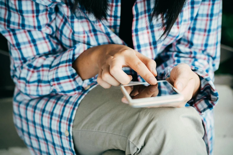 a close up of a person holding a cell phone, happening, wearing a linen shirt, from reading to playing games, wearing a cute top, teenage