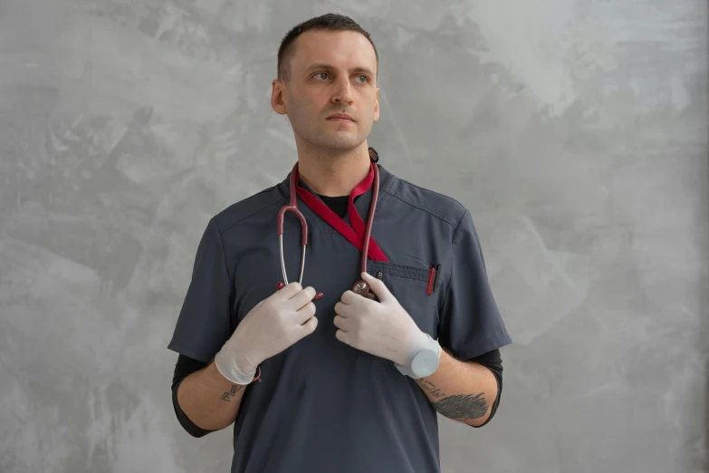 a man with a stethoscope around his neck, by Adam Marczyński, pexels contest winner, hyperrealism, red gloves, gray, uniform, confident stance