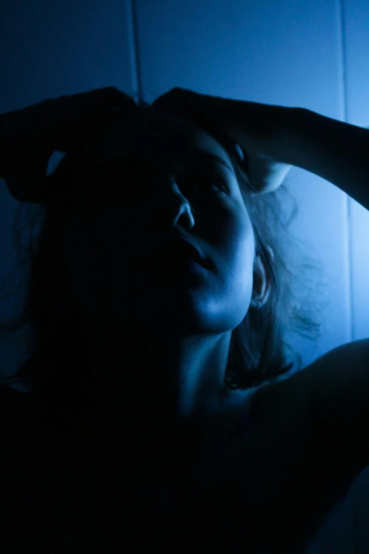 a woman laying in bed with her hand on her head, pexels, digital art, dramatic blue light, shadowy, concerned, ilustration
