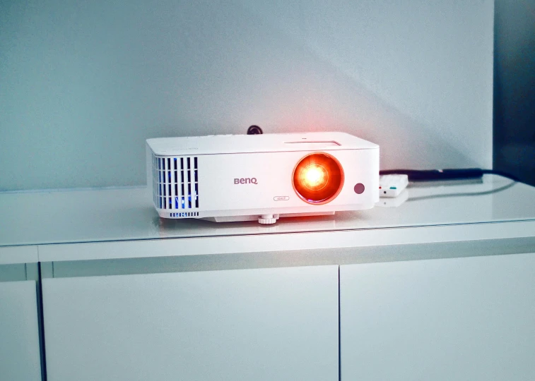 a projector sitting on top of a white counter, a brightly coloured, home display, product shot, burned