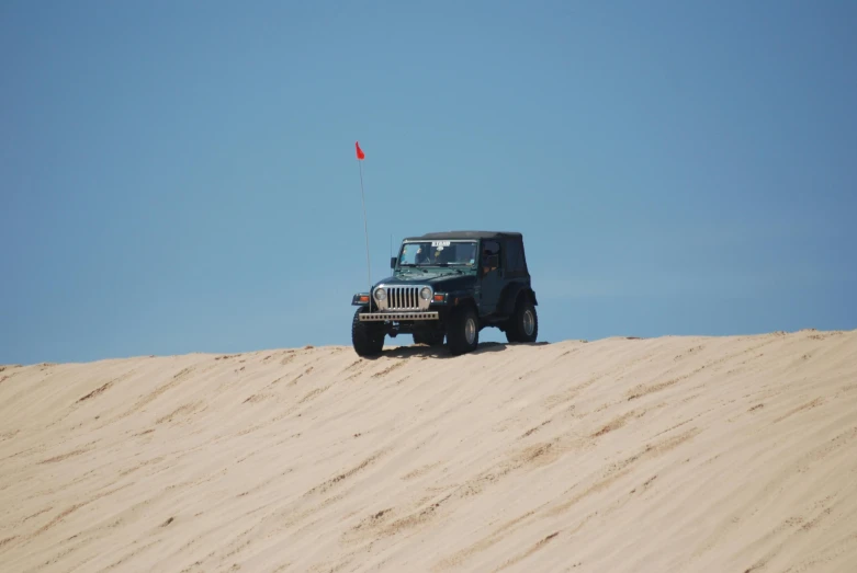 a jeep that is sitting in the sand, avatar image, craigville, red flag, top of the hill