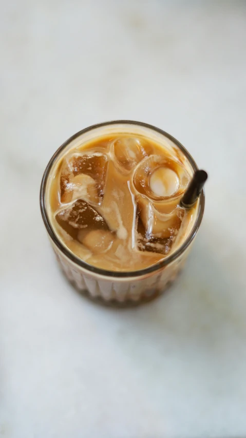 a glass of iced coffee sitting on top of a table, by Robbie Trevino, top - down photograph, square, may 1 0, kek