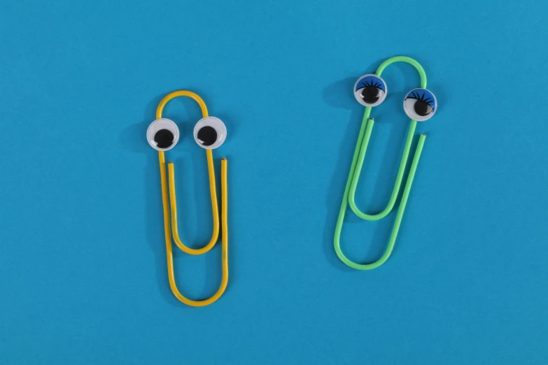 two paper clips with googly eyes on a blue background, pexels, teacher, slimy, piercing, modeled