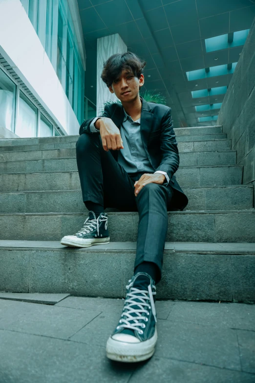 a man sitting on the steps of a building, an album cover, pexels contest winner, sumatraism, confident stance, androgyny, sayem reza, candid picture