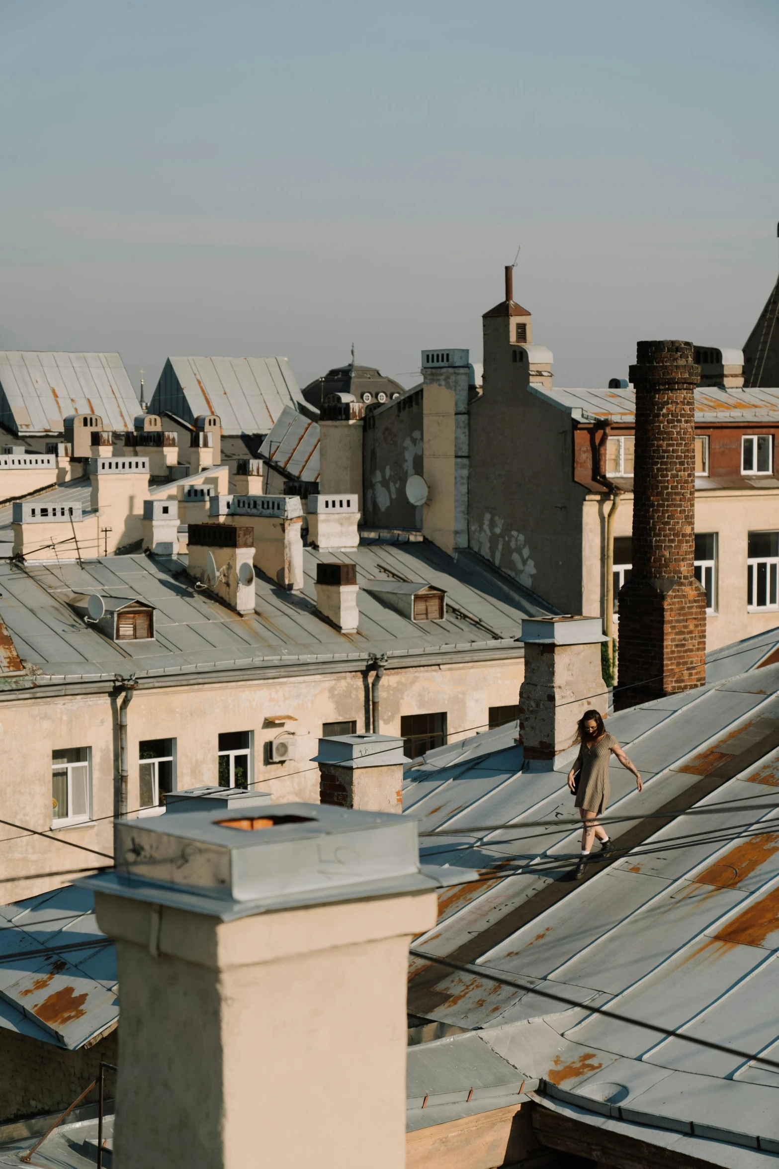 a person riding a skateboard on top of a roof, inspired by Vasily Surikov, unsplash contest winner, renaissance, tenement buildings, фото девушка курит, galvalume metal roofing, seen from far away