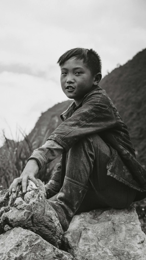 a black and white photo of a boy sitting on a rock, inspired by Nam Gye-u, realism, farmer, vietnam war soldier, 15081959 21121991 01012000 4k, medium format. soft light