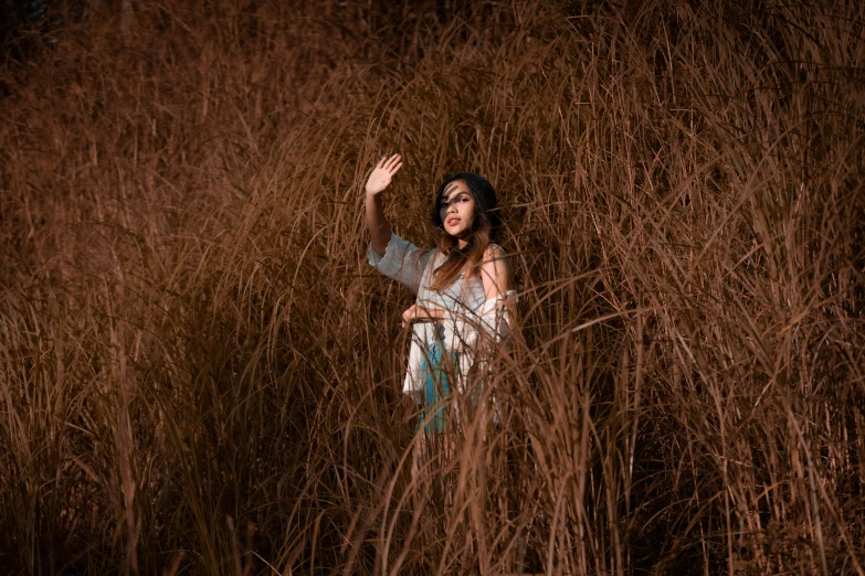a woman standing in a field of tall grass, inspired by Elsa Bleda, pexels contest winner, indian girl with brown skin, casting a protection spell, hd wallpaper, concert