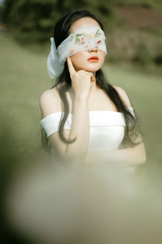 a woman in a white dress with a blind on her face, inspired by Yu Zhiding, pexels contest winner, renaissance, asian face, in field high resolution, translucent skin, blindfold