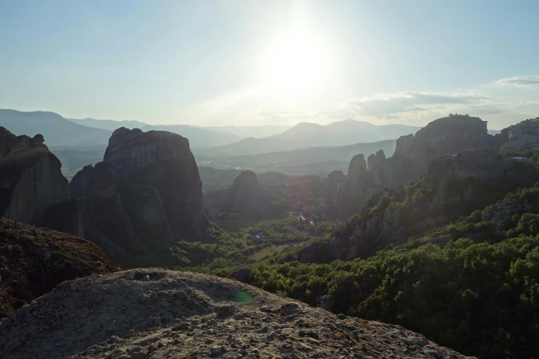 a person standing on top of a large rock, by Alexis Grimou, panorama of crooked ancient city, summer sunset, today\'s featured photograph 4k, gopro footage