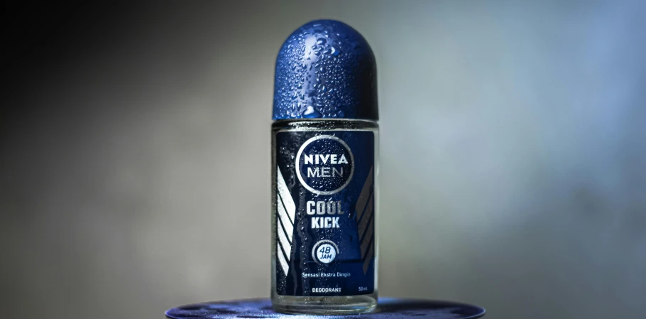 a close up of a bottle of deodorant, inspired by James Cowie, dark blue tones, doing a kick, nuka cola, cold mist