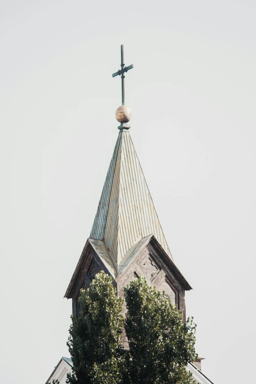 a church steeple with a cross on top, an album cover, by Karel Dujardin, trending on unsplash, renaissance, roof with vegetation, made of intricate metal and wood, elevation, low quality photo