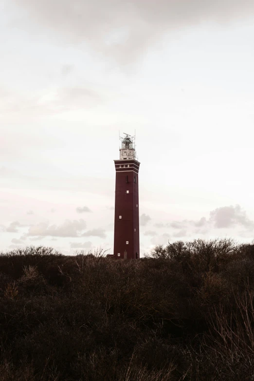 a red and white lighthouse sitting on top of a hill, by Jan Tengnagel, unsplash contest winner, modernism, brown, helmond, square, panoramic