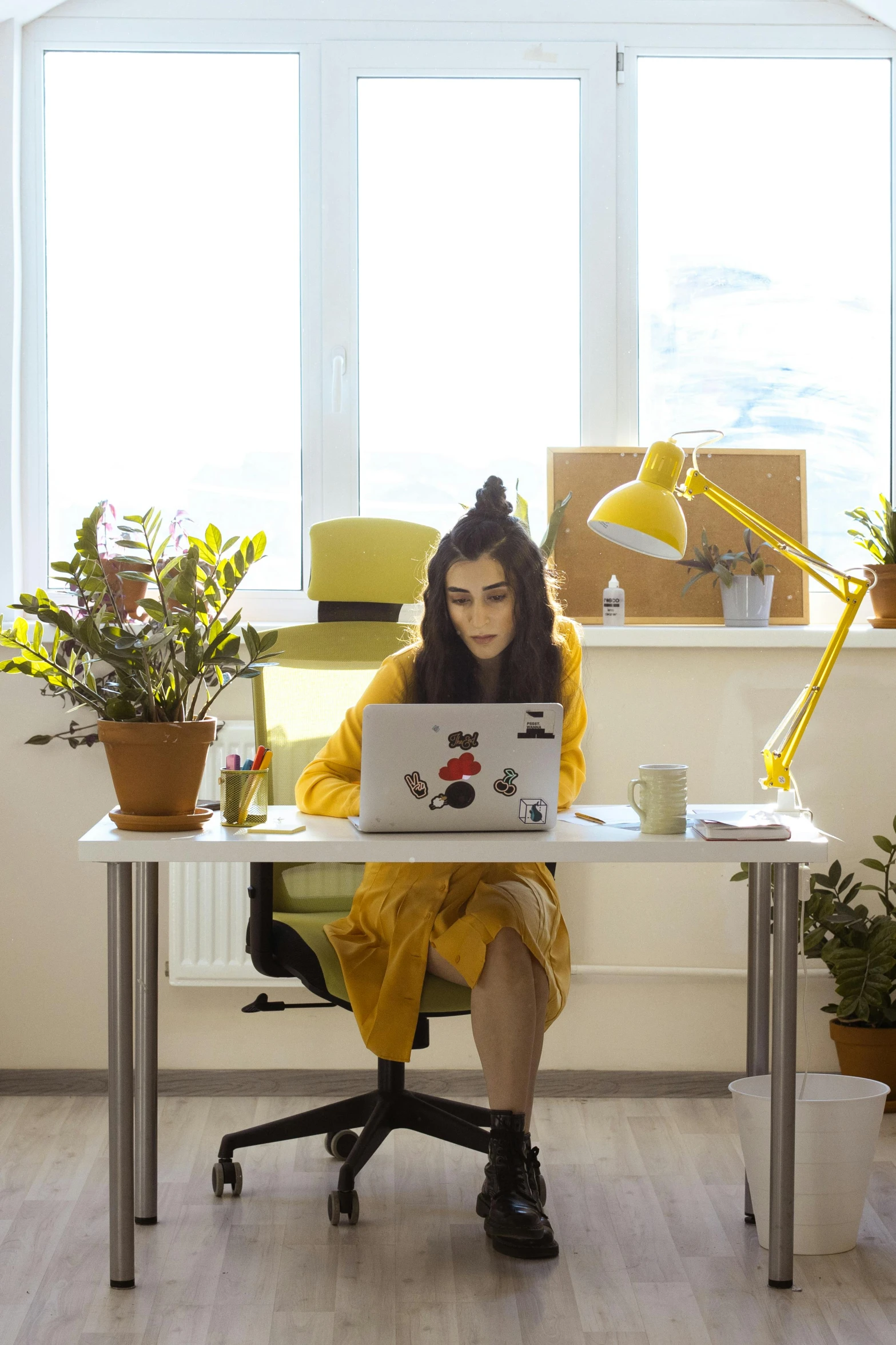 a woman sitting at a desk using a laptop computer, by Julia Pishtar, yellow clothes, h3h3, low quality photo, maxim sukharev