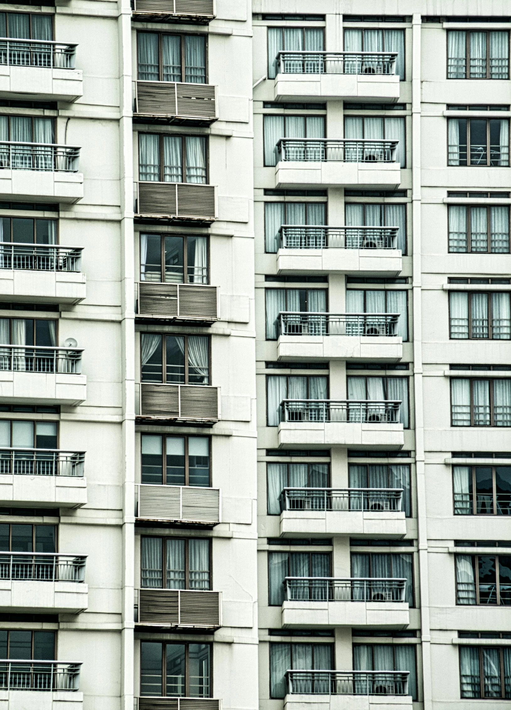 a tall building with lots of windows and balconies, inspired by Andreas Gursky, unsplash, hotel room, te pae, ten flats, rows of doors