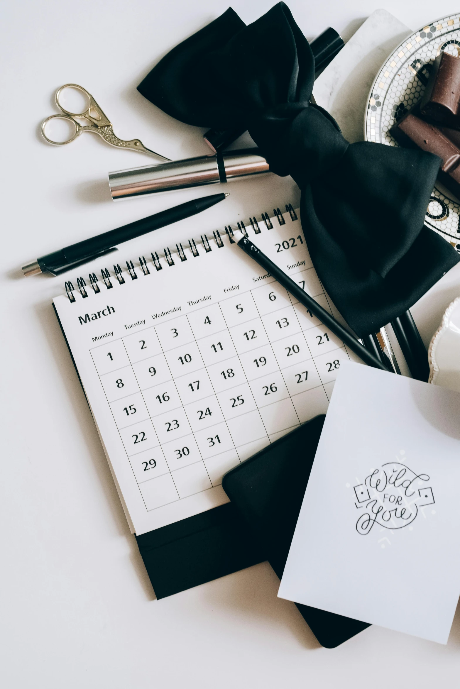 a cup of coffee sitting on top of a desk next to a calendar, exquisite black accessories, thumbnail, instagram post, uploaded