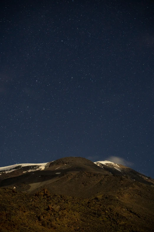 a mountain covered in snow under a night sky, hurufiyya, standing close to volcano, zoomed out, side, today's featured photograph