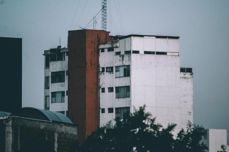 a couple of tall buildings sitting next to each other, inspired by Elsa Bleda, pexels contest winner, brutalism, old abandoned building, neo - andean architecture, in a suburb, white building