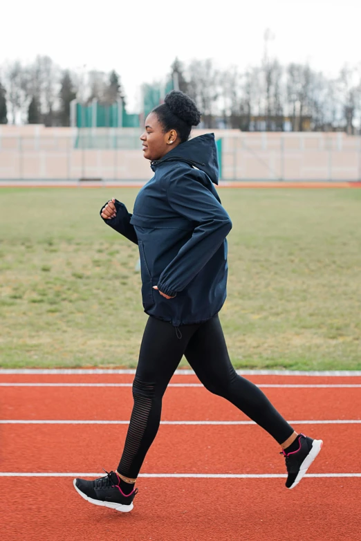 a woman running on a track on a cloudy day, by Jakob Gauermann, happening, jacket, dark-skinned, thumbnail, low quality photo